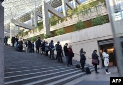Media and members of the public line up outside the British Columbia Supreme Court to attend the trial of Meng Wanzhou, the chief financial officer of Huawei Technologies on Dec. 7, 2018 in Vancouver BC.