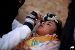 A child receives a polio vaccination during a house-to-house polio immunization campaign, in Sanaa, Yemen, Feb. 21, 2017.