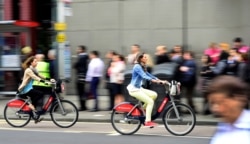 FILE - Commuters cycle past a bus stop outside Waterloo Station in London, Britain August 6, 2015.