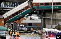 Cars from an Amtrak train lay spilled onto Interstate 5 below alongside smashed vehicles as some train cars remain on the tracks above, Dec. 18, 2017, in DuPont, Wash.