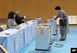 A voter casts her ballot in a general election at a polling station in Tokyo Sunday, Oct. 22, 2017
