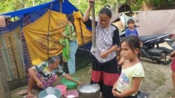 Aktivitas warga di salah satu tenda yang tidak mengenakan masker pelindung wajah untuk protokol kesehatan pencegahan COVID-19. Minggu (31/1/2021). (Foto: VOA/Yoanes Litha)