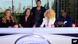 This photo provided by Fox, American Idol host Ryan Seacrest, center, poses with judges, from left, Mariah Carey, Keith Urban, Nicki Minaj and Randy Jackson, Sept. 16, 2012 in New York.