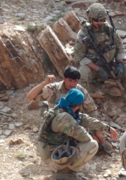 In this undated photo provided by Ryan Brummond, Mohammad Khalid Wardak, center, speaks to a U.S. solider in Afghanistan in Afghanistan