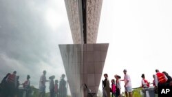 Visitors are reflected as they enter the Smithsonian National Museum of African American History and Cultural on the National Mall in Washington, May 1, 2017.