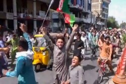 This screengrab taken from video from Pajhwok Afghan News shows Afghan people protesting over the reported removal of Afghan flags replaced with Taliban flags after the Taliban's military takeover of Afghanistan, in Jalalabad on August 18, 2021. …