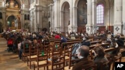Church-goers wearing face masks attend a church service at Saint-Francois-Xavier church in Paris, France, Nov. 29, 2020.