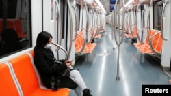 意大利首都罗马，一名戴着防护口罩的妇女坐在空荡的地铁里，这是意大利政府为减缓新冠病毒蔓延而实施史无前例封锁的第三天。(2020年3月12日)