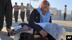 A woman mourns as she holds the body of her daughter, who died in an earthquake, in Sarpol-e-Zahab, western Iran, Nov. 13, 2017. 