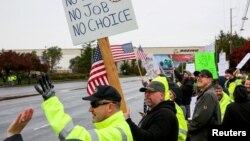 Boeing employees and others line the street with signs and American flags as they protest the company's coronavirus disease (COVID-19) vaccine mandate, outside the Boeing facility in Everett, Washington, October 15, 2021. REUTERS/Lindsey Wasson/File Phot