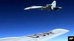 Pesawat jet Rusia Su-27 (atas) tampak mencegat pesawat Amerika RC-135 yang terbang di atas di atas Laut Baltik, Senin (19/6) lalu. 