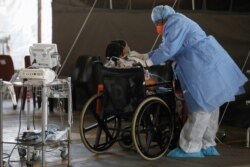Healthcare workers tend to a patient at a temporary ward set up during the coronavirus disease (COVID-19) outbreak, at Steve Biko Academic Hospital in Pretoria, South Africa, January 19, 2021.