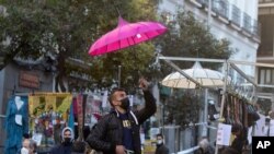 Seorang penjual mempersiapkan kiosnya di pasar loak Rastro di Madrid, Spanyol, Minggu, 22 November 2020. 