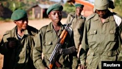 A child soldier (C), known as "Kadogo," meaning "small one" in Swahili, stands at the front line at Kanyabayonga in eastern Congo, November 17, 2008. 