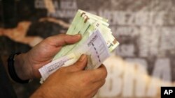  Seorang pria Iran menghitung uang dan cek perjalanan di Tehran, Iran, 21 Agustus 2019. (Foto: AP Photo/Ebrahim Noroozi)
