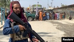 FILE - A member of the Taliban forces stands guard at the Pakistan-Afghanistan crossing border, in Torkham, Pakistan, September 2, 2021. 