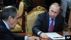 Presiden Rusia Vladimir Putin (kanan) mendengarkan penjelasan dari Menlu Sergei Lavrov dalam pertemuan di Moskow, Senin (14/3).