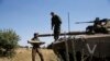 An Israeli soldier holds a tank shell near Alonei Habashan on the Israeli occupied Golan Heights, close to the cease-fire line between Israel and Syria, June 22, 2014.