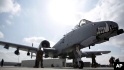 FILE - U.S. military personnel stand beside an A-10C fighter at Kandahar Airfield, Afghanistan, Jan. 23, 2018.