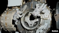 NASA spacewalkers (from left) Bob Behnken and Chris Cassidy set up the outside of the Tranquility module for the future installation of the NanoRacks airlock, July 21, 2020. (Credit: NASA)