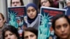 FILE - Demonstrators listen to speakers outside the 4th U.S. Circuit Court of Appeals, Jan. 28, 2020, in Richmond, Virginia. President Donald Trump's travel ban on travelers from predominantly Muslim countries went back before a federal appeals court.