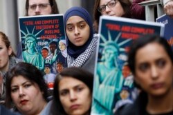 FILE - Demonstrators opposed to President Donald Trump's travel ban listen to speakers during a rally outside the U.S. 4th Circuit Court of Appeals, in Richmond, Virginia, Jan. 28, 2020.