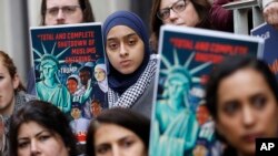 FILE - Demonstrators listen to speakers outside the 4th U.S. Circuit Court of Appeals, Jan. 28, 2020, in Richmond, Virginia. President Donald Trump's travel ban on travelers from predominantly Muslim countries went back before a federal appeals court.