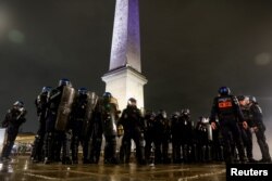 Police officers stand guard during a demonstration on Place de la Concorde to protest the use by French government of the article 49.3, a special clause in the French Constitution, to push the pensions reform bill through the National Assembly without a vote by lawmakers, in Paris, France, March 17, 2023.