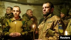 Anggota Brigade Mekanik Chorni Zaporozhtsi ke-72 Ukraina mengikuti misa Malam Natal di garis depan, di tengah serangan Rusia di Donetsk, pada 24 Desember 2024. (Foto: via Reuters)