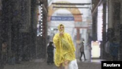 14호 태풍 '난마돌'이 18일 일본에 상륙한 가운데 비옷을 입은 주민이 이동하고 있다. 