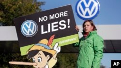 Seorang aktivis Greenpeace melakukan protes di depan pabrik Volkswagen di kota Wolfsburg, Jerman (25/9).