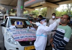 A man reacts as a health worker in protective suit takes his nasal swab sample to test for COVID-19 in New Delhi, India, May 22, 2021.