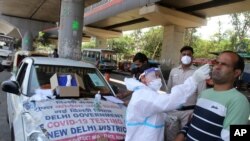 A man reacts as a health worker in protective suit takes his nasal swab sample to test for COVID-19 in New Delhi, India, May 22, 2021. 