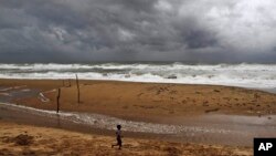 Seorang anak laki-laki India bermain di pantai pesisir Teluk Benggala dekat Gopalpur, di Ganjam district, 140 kilometer dari selatan Bhubaneswar, India (11/10). (AP/Biswaranjan Rout)