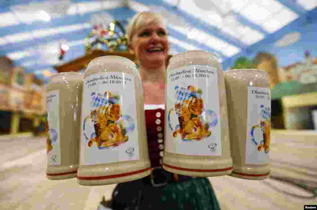 Seorang pelayan menyajikan gelas bir selama festival Oktoberfest terbesar di dunia di Munich, Jerman.