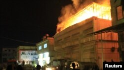 Pemberontak Suriah berusaha memadamkan kobaran api setelah serangan artileri pasukan Suriah menghantam gedung di distrik Saqba, pinggiran Damaskus. 