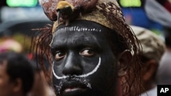 Seorang aktivis Papua dengan hiasan kepala tradisional mengikuti demonstrasi memprotes perusahaan tambang Amerika, Freeport McMoRan di Jakarta, Indonesia, 20 Maret 2017.