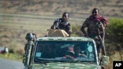 FILE - Ethiopian government soldiers ride in the back of a truck on a road near Agula, north of Mekele, in the Tigray region of northern Ethiopia, May 8, 2021.