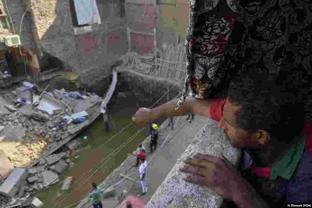 Ramy, a resident of Shobra, an informal neighborhood in northern Cairo, watches as survivors are sought in a collapsed building. Many buildings have gone up without permits, soil surveys or inspections. Ramy worries the collapse may not stop there and his home could be next. &ldquo;Buildings are like dominos here.&rdquo;