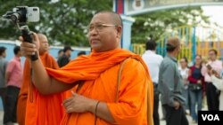 រូបឯកសារ៖ ព្រះតេជគុណ លួន សុវាត កំពុងថតសកម្មភាពទូទៅ នៅខាងមុខមណ្ឌលអប់រំកែប្រែទី១ កាលពីល្ងាចថ្ងៃទី២៧ ខែសីហា ឆ្នាំ ២០១៨ រាជធានីភ្នំពេញ។ (ទុំ ម្លិះ/វីអូអេ)