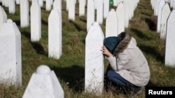 FILE - A woman visits a grave of her family members in the memorial center Potocari near Srebrenica, Bosnia and Herzegovina, after the court proceedings of former Bosnian Serb general Ratko Mladic, Nov. 22, 2017.