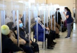 Seniors sit in a waiting room after receiving their vaccine against the coronavirus as Quebec begins vaccinations for seniors over 85 years old in Laval, Quebec, Canada, Feb. 25, 2021.