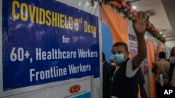 បុរស​ជនជាតិ​ឥណ្ឌា​ម្នាក់ លើកដៃ​ទៅ​ម៉ាស៊ីនថត មុន​ពេល​ទទួល​ការចាក់​វ៉ាក់សាំង​លើក​ទីបី​សម្រាប់​បង្ការ​ជំងឺ​កូវីដ១៩ នៅ​មន្ទីរពេទ្យ​រដ្ឋាភិបាល​ក្នុង​ទីក្រុង Gauhati ប្រទេស​ឥណ្ឌា កាលពី​ថ្ងៃទី១០ ខែមករា ឆ្នាំ២០២២។