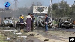 This frame grab from video provided by the Thiqa News Agency shows rebel gunmen at the site of a blast that damaged several buses and vans at the Rashideen area, a rebel-controlled district outside Aleppo city, Syria, April. 15, 2017.