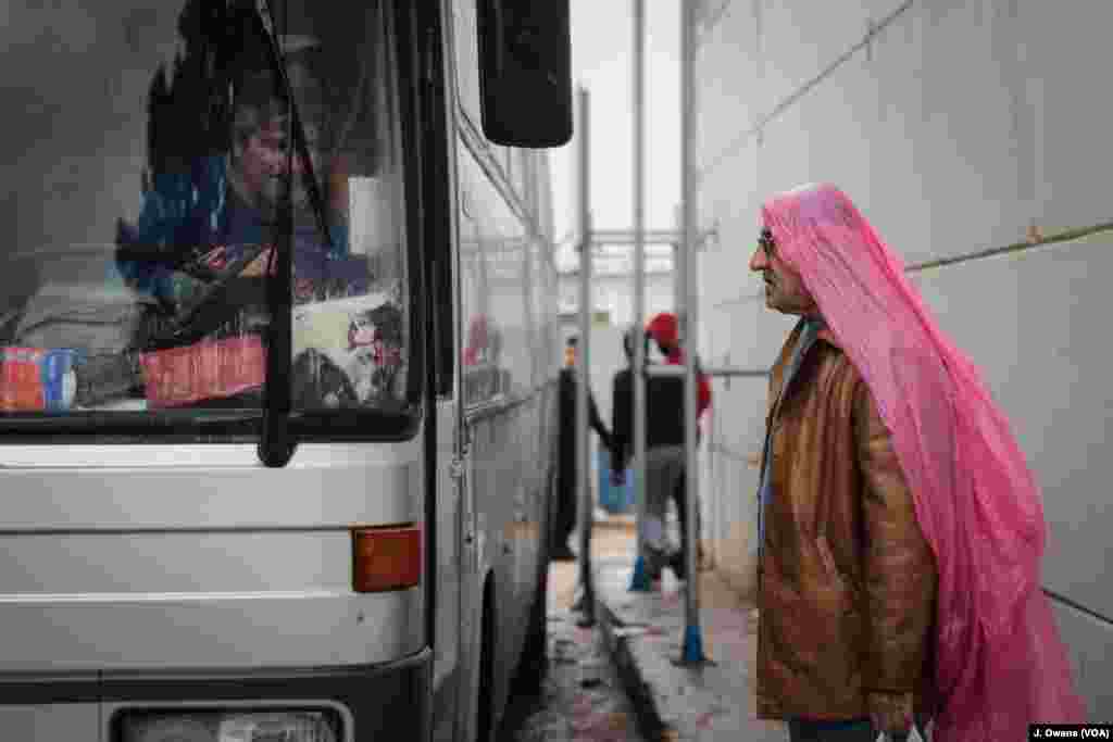 A man prepares to board a bus leaving Vial camp in Chios. 