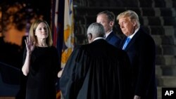 President Donald Trump watches as Supreme Court Justice Clarence Thomas administers the Constitutional Oath to Amy Coney Barrett on the South Lawn of the White House in Washington, Oct. 26, 2020, after Barrett was confirmed by the Senate earlier.