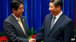 10일 중국 베이징의 인민대회당에서 아베 신조 일본 총리(왼쪽)와 시진핑 중국 국가주석이 만나 악수하고 있다.