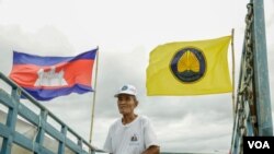 រូបឯកសារ៖ អ្នកគាំទ្រម្នាក់ឈរលើរថយន្តដែលមានដោតទង់ជាតិខ្មែរនិងទង់គណបក្ស​ហ្វ៊ុន​ស៊ិនប៉ិច​ ក្នុង​ថ្ងៃ​ដំបូង​ការ​ឃោស​នា​បោះ​ឆ្នោត​​ថ្នាក់ជាតិ នៅរាជធានីភ្នំពេញ​ នៅថ្ងៃ​ទី​៧ ខែ​កក្កដា​ ឆ្នាំ​២០១៨។​ (ខាន់​ សុគុំ​មនោ​/វីអូអេ) 