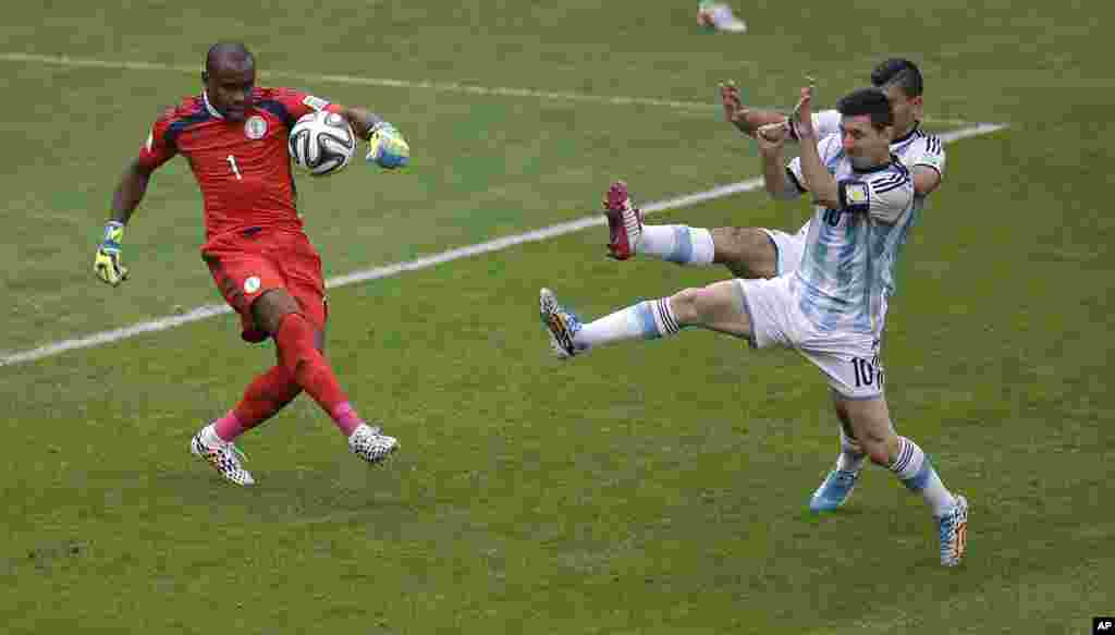 Le gardien du Nigeria Vincent Enyeama contrecarre une attaque de Lionel Messi de l&#39;Argentine, devant lui à droite, et Sergio Aguero, lors du match de football Coupe du monde de F de groupe entre le Nigeria et l&#39;Argentine au stade de Beira-Rio de Porto Alegre, au Brésil, mercredi 25 Juin 2014. 