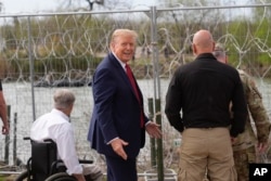 Kandidat presiden dari Partai Republik, mantan Presiden Donald Trump, memberi isyarat setelah melambai kepada orang-orang di seberang Rio Grande di Meksiko di Shelby Park saat berkunjung ke perbatasan AS-Meksiko, Kamis, 29 Februari 2024, di Eagle Pass, Texas. (Foto: AP/Eric Gay)